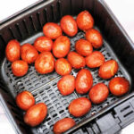 Freshly cooked baby red potatoes, nestled in a black air fryer basket, offer a delightful twist on your favorite baby potatoes recipe.