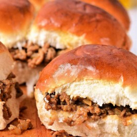 Sloppy Joe sliders on a wooden board, with toasted buns hugging the savory Sloppy Joe meat filling.