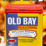 A container of Old Bay seasoning is shown. The label indicates it has 30% less sodium than the original. Suggested for seafood, poultry, salads, and meats, it's perfect for various old bay recipes. The net weight is 2.62 ounces (74 grams). Text at the top reads "How to Make Old Bay.