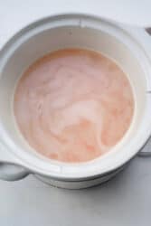 A white pot filled with the delightful flavors of slow-cooked lentils on a light background.