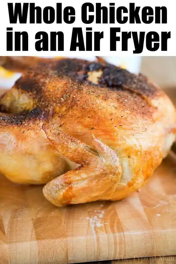 A cooked air fryer whole chicken with crispy, golden-brown skin is placed on a wooden cutting board. The text at the top reads, "Whole Chicken in an Air Fryer.