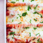 A baking dish with cheesy enchiladas topped with herbs, labeled Easy Enchiladas in the Oven, answers the question of how long to cook enchiladas to perfection.