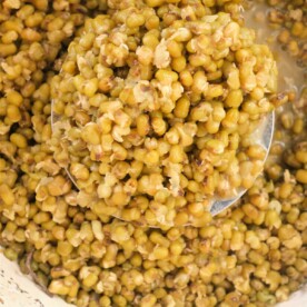 A pot filled with perfectly cooked mung beans, with a ladle elegantly scooping some from the center—a glimpse into mastering how to cook mung beans.