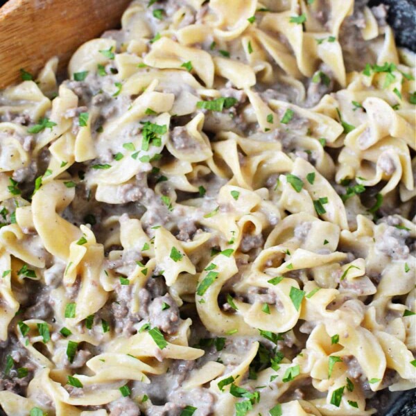 A skillet with creamy Hamburger Helper Beef Stroganoff and egg noodles, garnished with parsley.