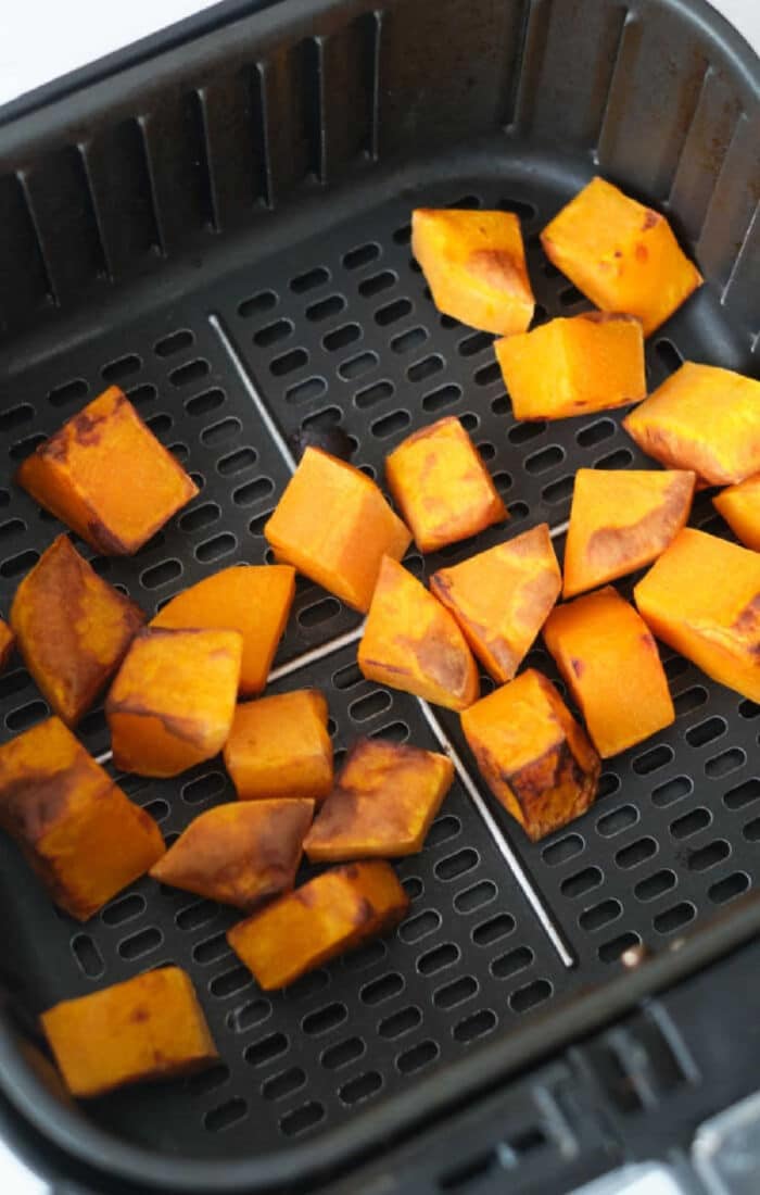 Golden cubes of air fryer butternut squash roasted to perfection, ready to enjoy straight from the basket.