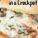 A close-up of a sandwich filled with a creamy chicken mixture garnished with chives. The text at the top reads "Cream Cheese Chicken in a Crockpot," perfect for those seeking delicious crockpot chicken recipes with cream cheese.