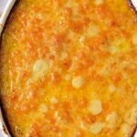 An oval dish filled with a baked, golden-brown creation labeled "Dairy Free Scalloped Potatoes" at the top of the image. The dish boasts a slightly crispy top layer, with perfectly browned edges adding to its appeal.