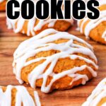 Iced Pumpkin Cheesecake Cookies are displayed on a wooden surface. They are round, soft-looking cookies topped with white icing drizzled in a zigzag pattern. The image has large bold text at the top that reads "Iced Pumpkin Cheesecake Cookies.