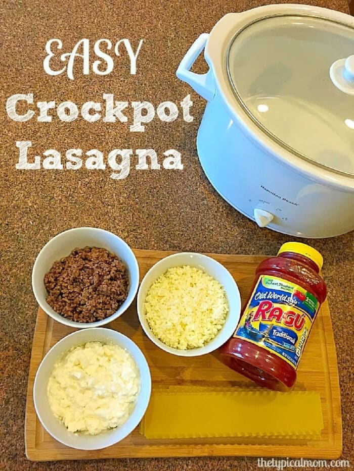 Crockpot lasagna recipe with no boiling required. Great pasta dinner your whole family will love using just a few ingredients and cooks quickly in your slow cooker. I will never make lasagna in the oven again after this! #crockpot #lasagna #crockpotrecipes #slowcooker #thetypicalmom #casserole Crockpot with cooked beef, shredded cheese, ricotta, lasagna noodles, and a jar of pasta sauce on a board—perfect for an easy crockpot lasagna recipe.