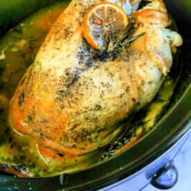 Savor the tenderness of slow-cooked turkey crown, seasoned with herbs and topped with a slice of orange in our easy slow cooker recipe.