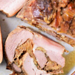 Close-up of sliced pork roulade with a crispy outer layer on a plate.