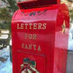 Festively decorated red mailbox labeled LETTERS FOR SANTA, set outdoors in the snow—perfect for children to send a letter to Santa.