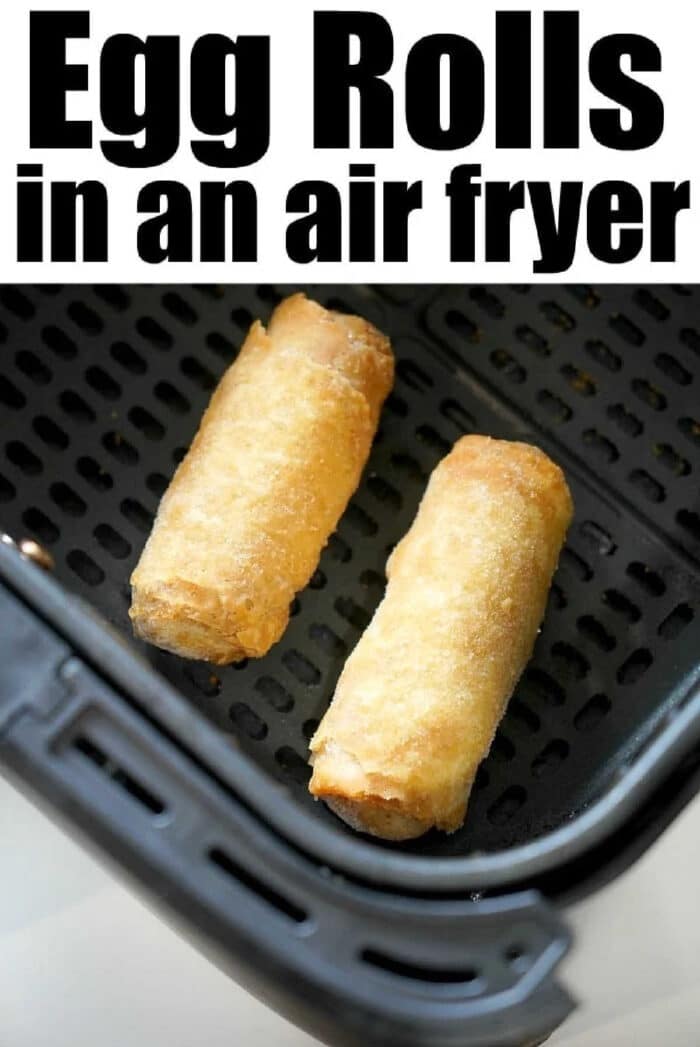 Two frozen egg rolls cooking in an air fryer basket, with text reading Egg Rolls in an air fryer above.