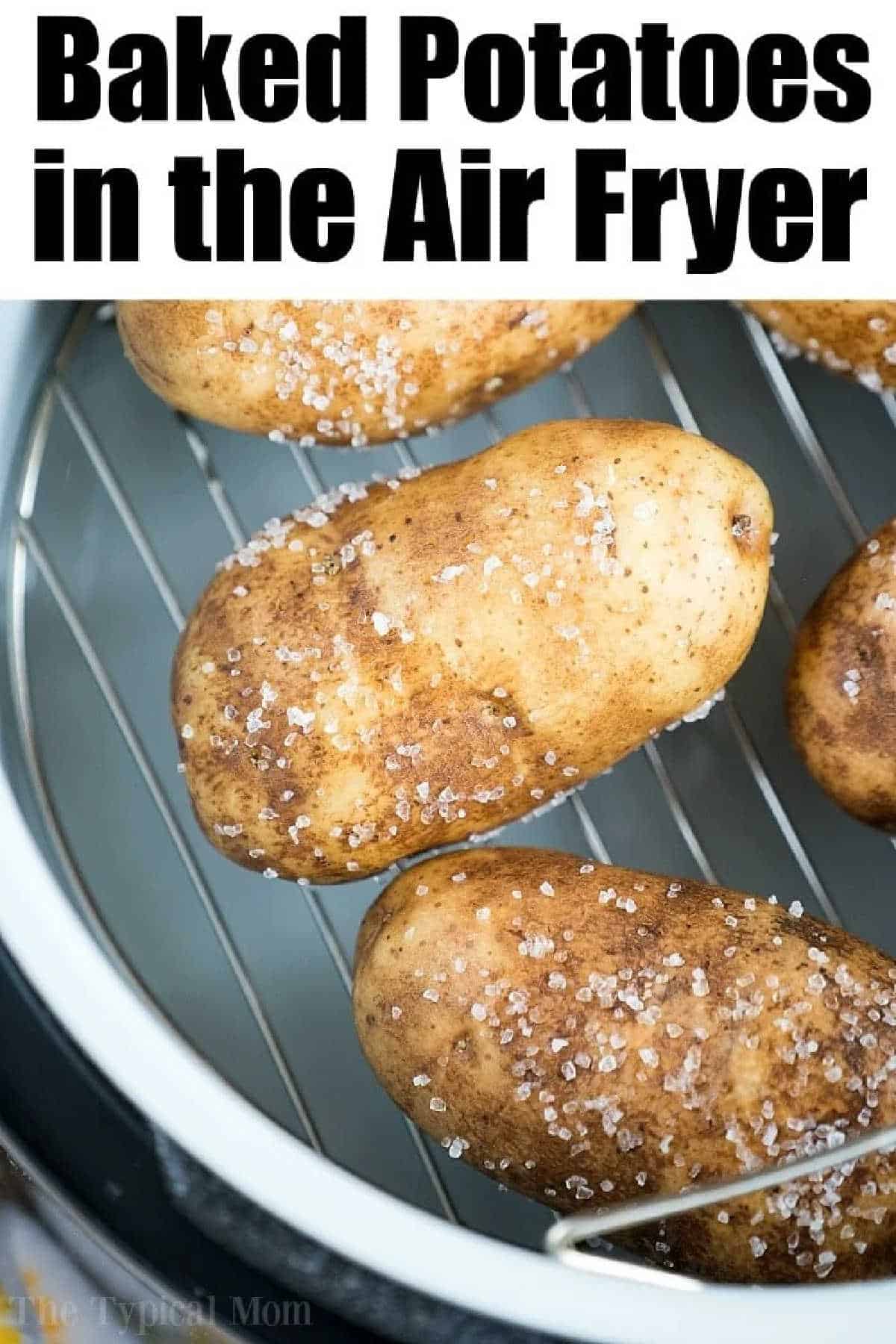 Air fryer baked potatoes are so amazing! With crispy skins on the outside and a soft tender inside it's the perfect side dish or dinner stuffed with chili! #airfryerrecipes #airfryer #bakedpotatoes #sidedishes #potatoes #thetypicalmom #ninjafoodi #ninjafoodirecipes Four salted russet potatoes on a metal rack inside an air fryer, ready for baking the perfect air fryer baked potatoes.