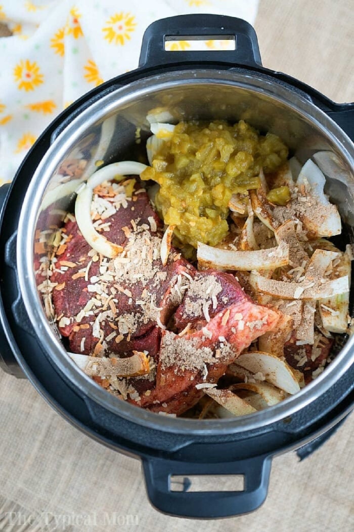 French onion pressure cooker roast is tender with tons of flavor. Perfect Instant Pot shredded beef tacos for dinner even your kids will rave about. #instantpotrecipes #instantpot #roast #frenchonion #tacos #shreddedbeef #ninjafoodirecipes #crockpotexpressrecipes #pressurecookerrecipes Chunks of beef, sliced onions, seasonings, and green chiles make this a savory French onion pressure cooker roast, all ready to be cooked in the Instant Pot.