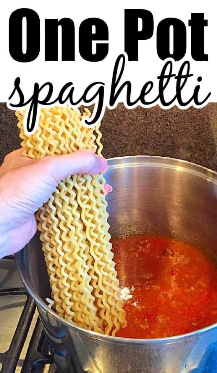 Hand holding wavy spaghetti noodles over a pot of red sauce on the stovetop; text reads One Pot Spaghetti, making dinnertime simple and delicious.