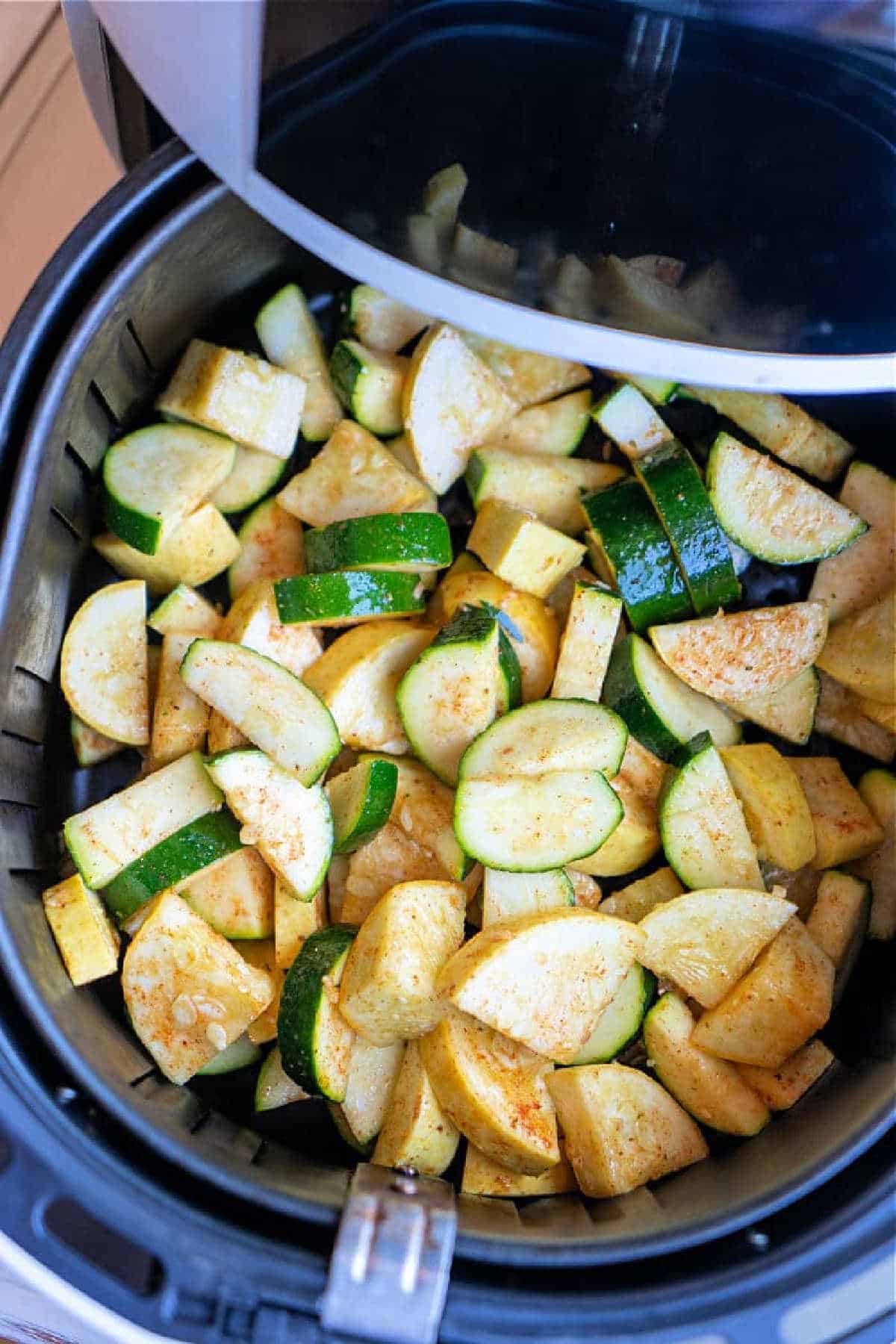 Air Fryer Squash and Zucchini, perfectly seasoned, are arranged in an air fryer basket, ready for crispy cooking.