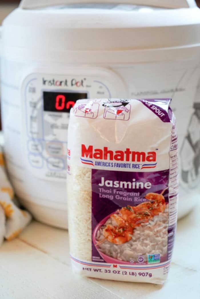 A bag of Mahatma Jasmine rice sits on a kitchen counter in front of an Instant Pot, perfect for cooking jasmine rice in an Instant Pot effortlessly.