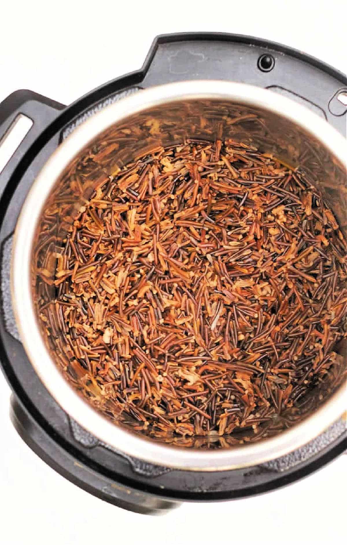 Cooked wild rice and black rice inside an Instant Pot, viewed from above on a white background.