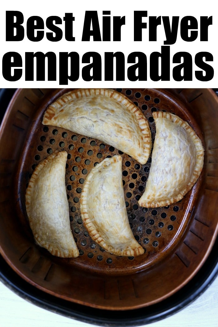 Four golden empanadas rest in an air fryer basket, with the words Best Air Fryer Empanadas proudly displayed above.