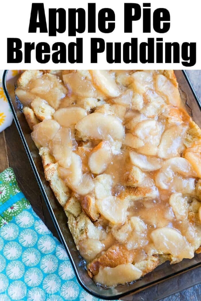 A glass dish filled with warm apple pie bread pudding, topped with sliced apples and a sweet glaze.