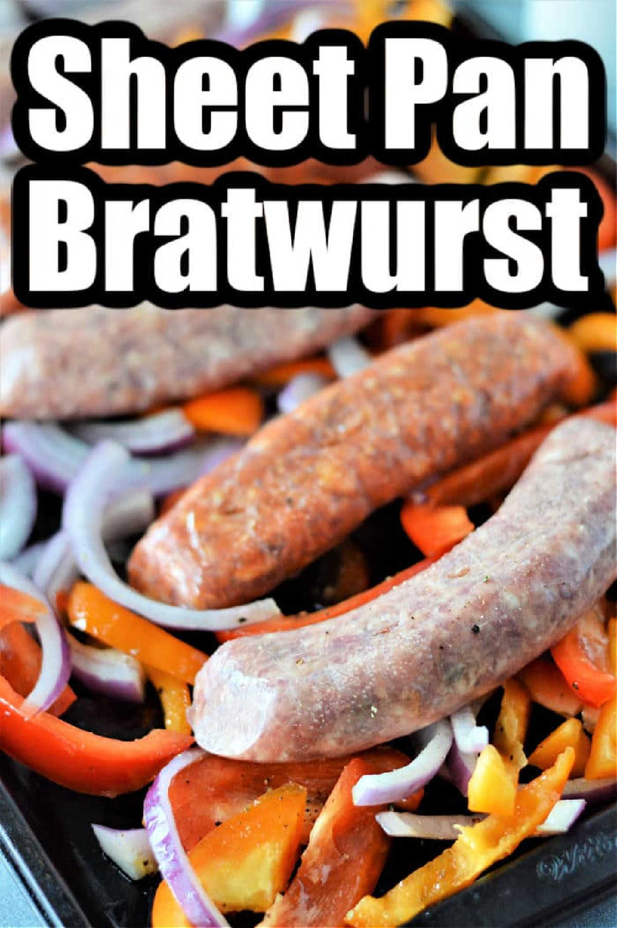 Raw bratwursts, sliced bell peppers, and onions arranged on a sheet pan—this is an easy way for how to cook bratwurst in the oven for a simple and flavorful meal.