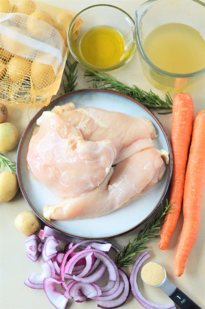 Dutch Oven Chicken Breast with carrots, potatoes, red onion, broth, rosemary, and garlic powder on a plate.