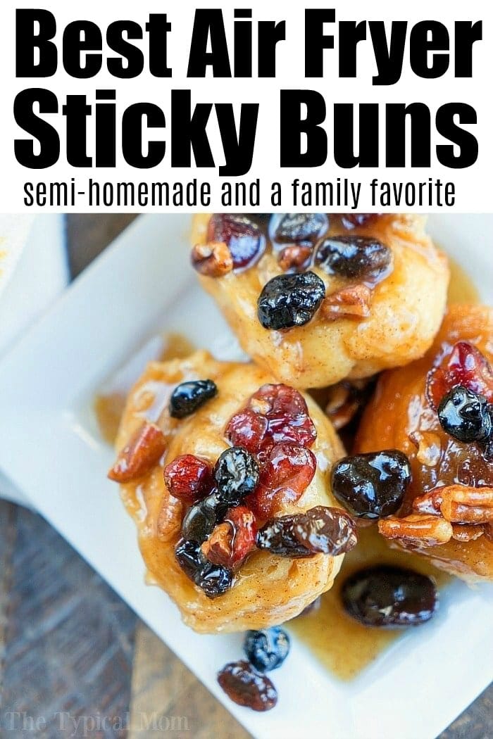 Three sticky buns topped with nuts and dried fruit on a white plate, viewed from above&mdash;perfect inspiration for air fryer dessert recipes.