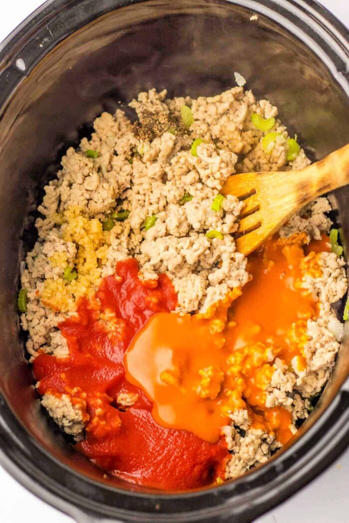 Mix ground chicken, diced peppers, and sauces in a slow cooker with a wooden spoon. For those considering alternatives like ground chicken, be aware of the different cooking times required to ensure the perfect texture and flavor.