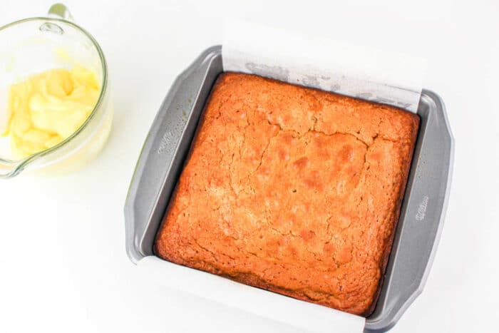 Banana cake baked in a 9x9 inch pan with golden brown edges and a soft, moist center.