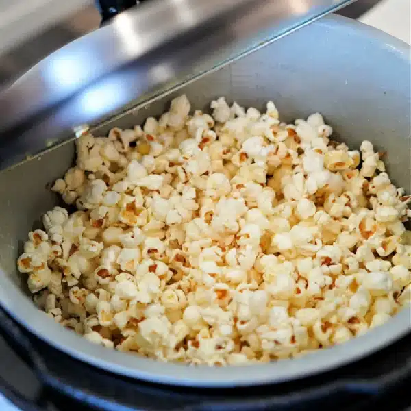 A pot filled with freshly popped popcorn inside an open Ninja Foodi pressure cooker.