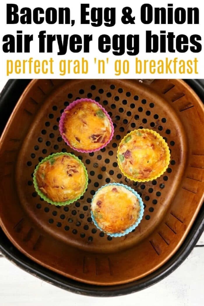 Air fryer egg bites like Starbucks filled with bacon, cheese and onions are the best low carb and keto breakfast idea ever! Like Starbucks egg bites but customized! #airfryer #airfryerrecipes #ninjafoodirecipes #eggbites #starbuckseggbites #airfryereggbites Four air fryer egg bites with bacon, egg, and onion sit in colorful silicone cups inside an air fryer basket.