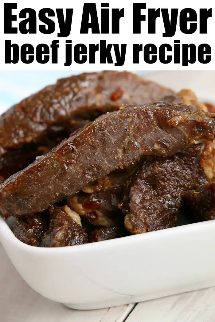 A close-up of a white bowl filled with pieces of dark brown beef jerky.