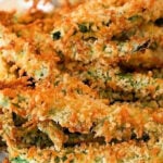 Crispy baked zucchini fries coated in golden breadcrumbs, stacked on a white plate, reminiscent of the irresistible crunch found in Air Fryer Green Bean Fries.