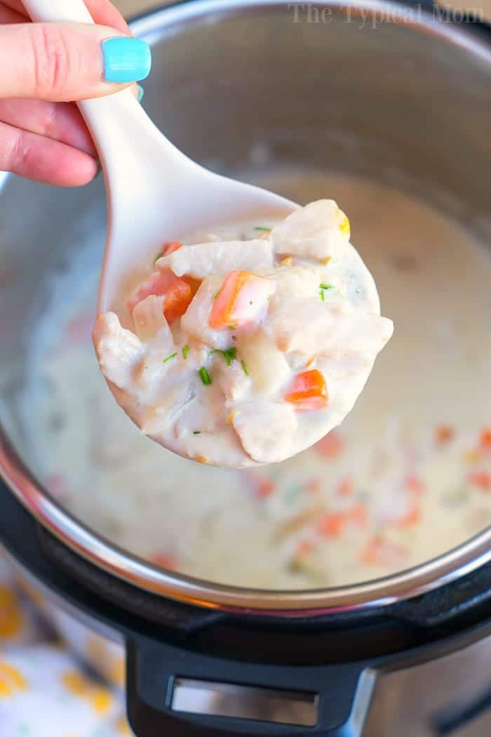A hand holds a ladle of creamy chicken and vegetable soup over an Instant Pot, transforming leftover chicken breast into a savory delight.