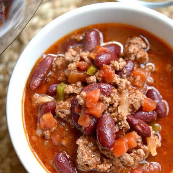 A bowl of instant pot chili with ground meat, red kidney beans, and diced vegetables in a rich, red sauce.