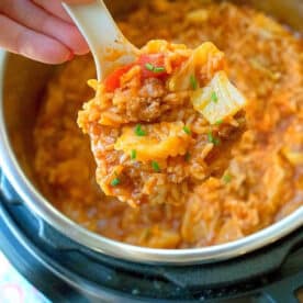 A spoonful of instant pot stuffed cabbage casserole being lifted from an Instant Pot.