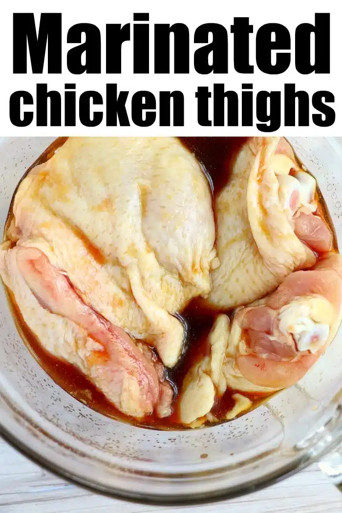 Raw chicken thighs in a glass bowl soaking in dark marinade, highlighted by bold text reading Marinated chicken thighs—perfect for making delicious marinated chicken in air fryer meals.