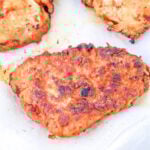 Golden-brown fried chicken pieces, perfectly cooked after learning how long to deep fry chicken breast, drain on white paper towels.