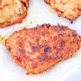 Golden-brown fried chicken pieces, perfectly cooked after learning how long to deep fry chicken breast, drain on white paper towels.