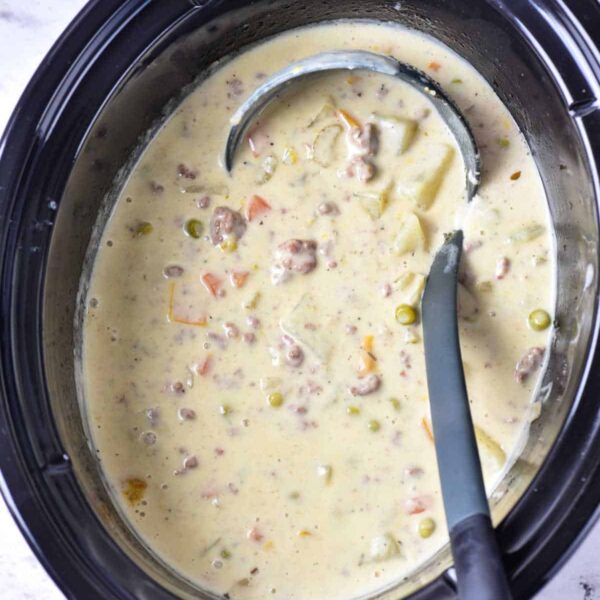 Creamy potato and hamburger soup with vegetables and chunks of meat, simmered to perfection in a crockpot, invitingly ladled into bowls.