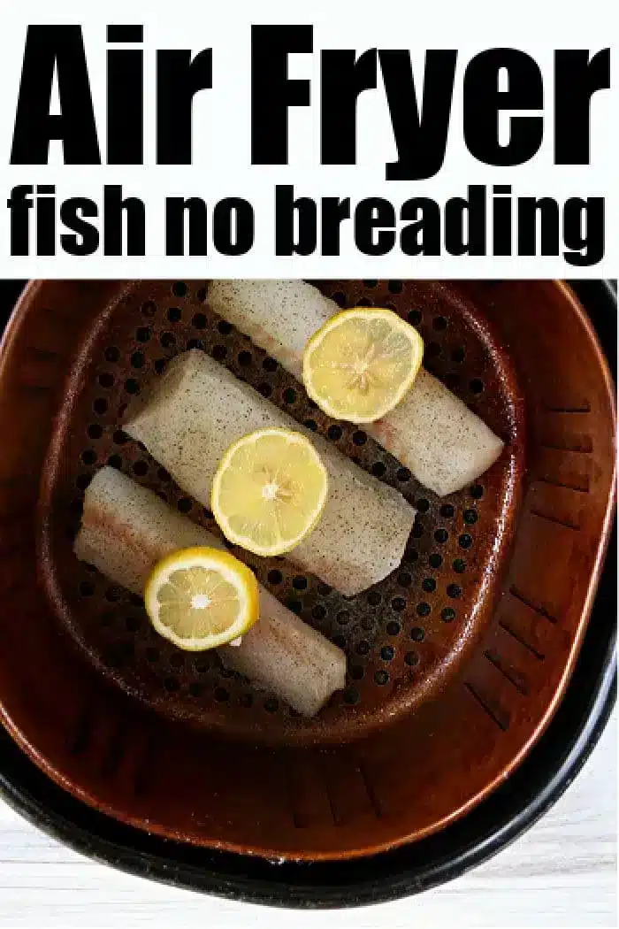 A close-up of three pieces of fish seasoned with black pepper and topped with lemon slices inside an air fryer basket. The text at the top reads, "Air Fryer Fish No Breading.