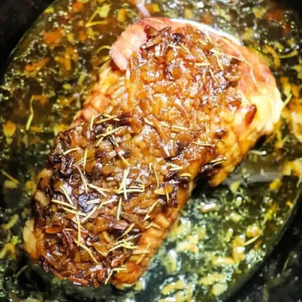 Pork roast topped with rosemary and onions, simmering in flavorful juices and Slow Cooker Pork Roast Onion Soup Mix for a savory, effortless meal.