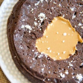 pressure cooker brownie with a melted peanut butter center, sprinkled with powdered sugar on a white plate—perfect for fans of pressure cooker brownies seeking a quick, decadent treat.