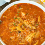 A bowl of hearty slow cooker stuffed cabbage soup with a rich tomato broth, shredded cabbage, rice, and fresh herbs on top.