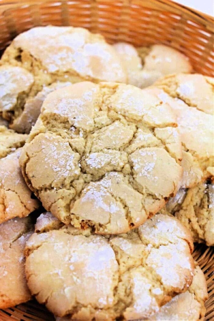 A basket filled with cracked, golden brown 3 Ingredient Cake Mix Cookies, dusted lightly with powdered sugar.