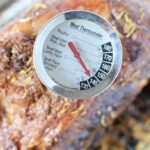 A close-up image of a meat thermometer inserted into a boneless rib roast. The thermometer shows various types of meats and their corresponding cooking temperatures. The text "How to Cook boneless rib roast recipe" is displayed at the top.