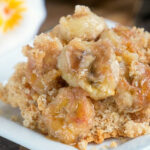 Close-up of banana dump cake, featuring caramelized bananas served on a square white plate.