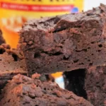 Close-up of rich, moist pumpkin brownies stacked on top of each other. In the background, partially blurred, is a can of Libby's 100% Pure Pumpkin, hinting at the delicious blend of flavors.