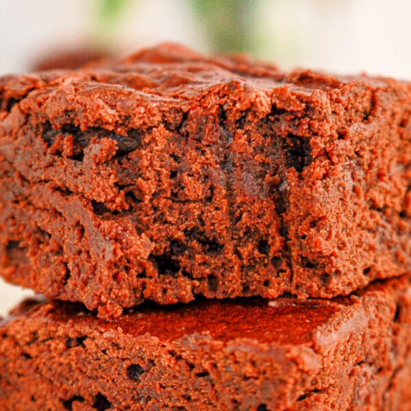 Close-up of two stacked black bean brownies made with brownie mix with a soft, crumbly texture, perfectly showcasing the rich mix of flavors.